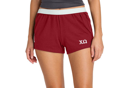 Person wearing red shorts with a logo on a white background