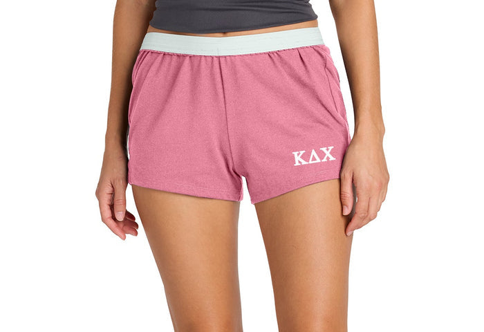 Person wearing pink shorts with 'KAX' logo on a white background