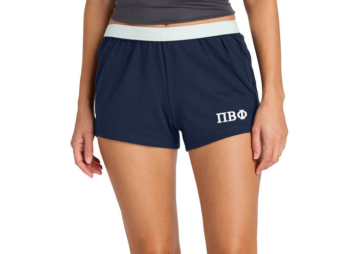 Person wearing navy shorts with a logo on a white background