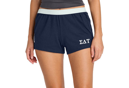 Person wearing navy shorts with a logo on a white background